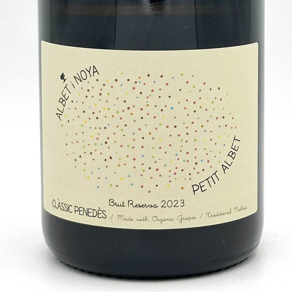 Wine bottle with a label featuring colorful dots and text on a white background