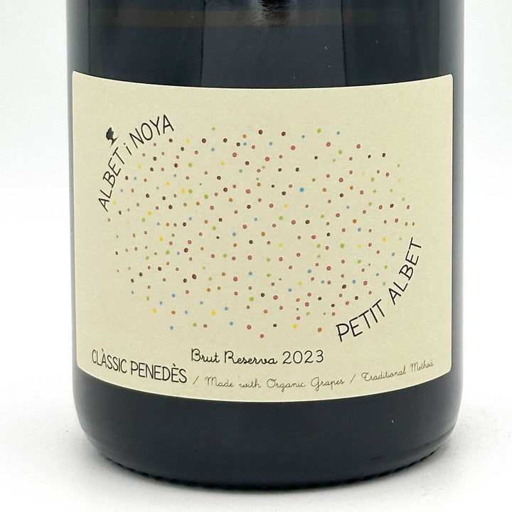 Wine bottle with a label featuring colorful dots and text on a white background