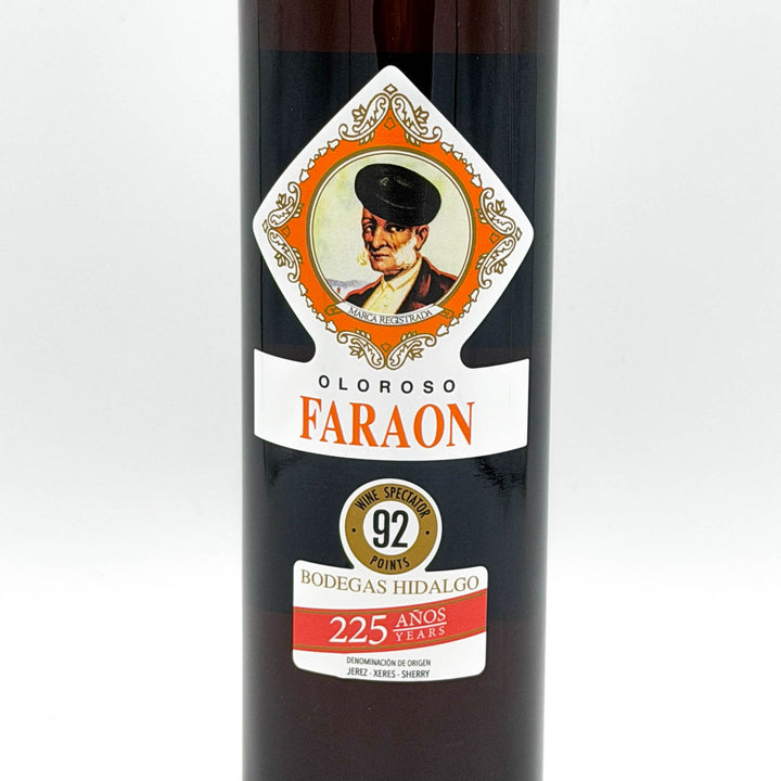 A bottle of Oloroso Faraon aged sherry from Bodegas Hidalgo, featuring a dark glass bottle with a detailed vintage-style label showing a portrait and orange, white, and red text.