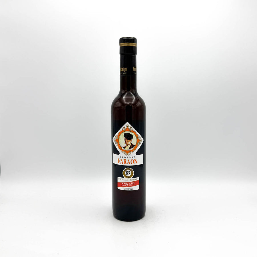 A dark glass bottle of Faraon Egyptian Aromatic Spirits with a black cap and a decorative label, centered on a light gray background.