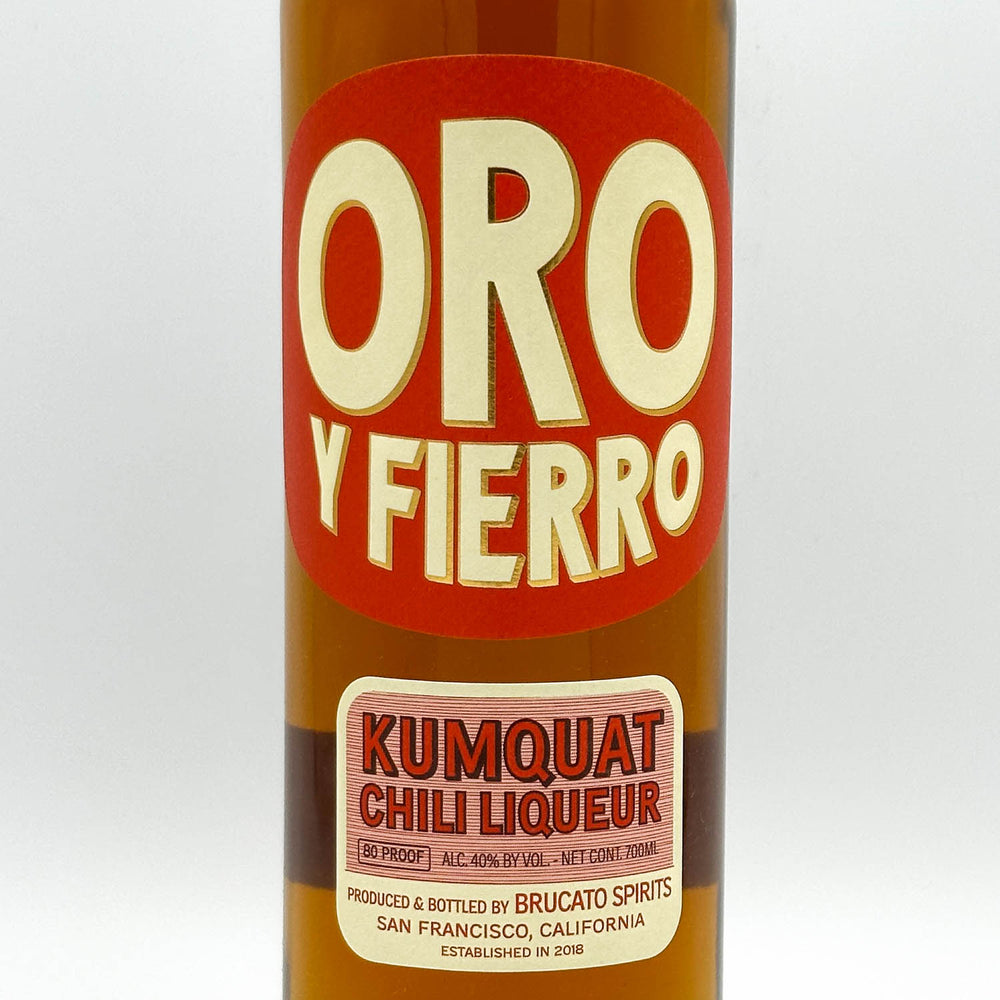 Bottle of Oro y Fierro Kumquat Chili Liqueur with a red label on a white background