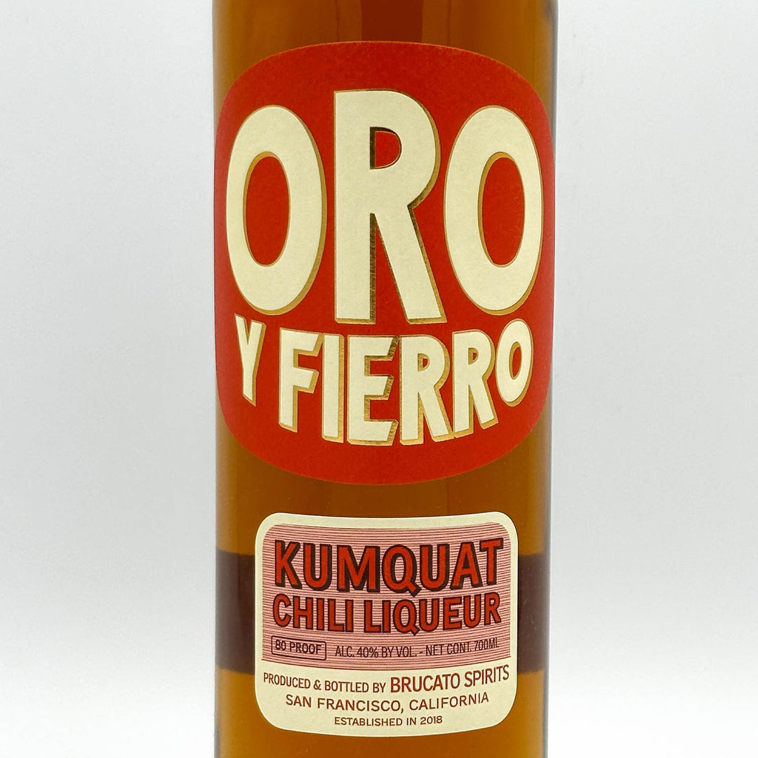 Bottle of Oro y Fierro Kumquat Chili Liqueur with a red label on a white background