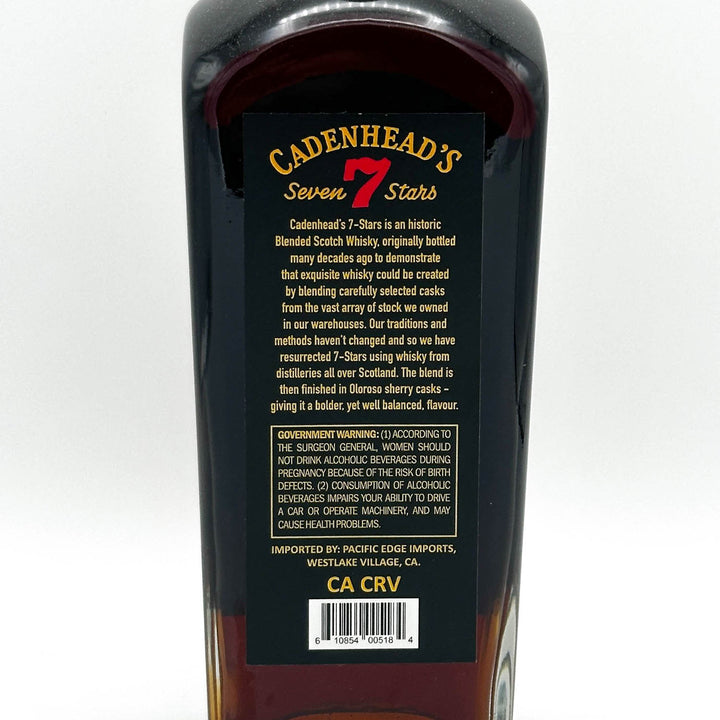 Bottle of Cadenhead's Seven Stars whisky with label on a white background