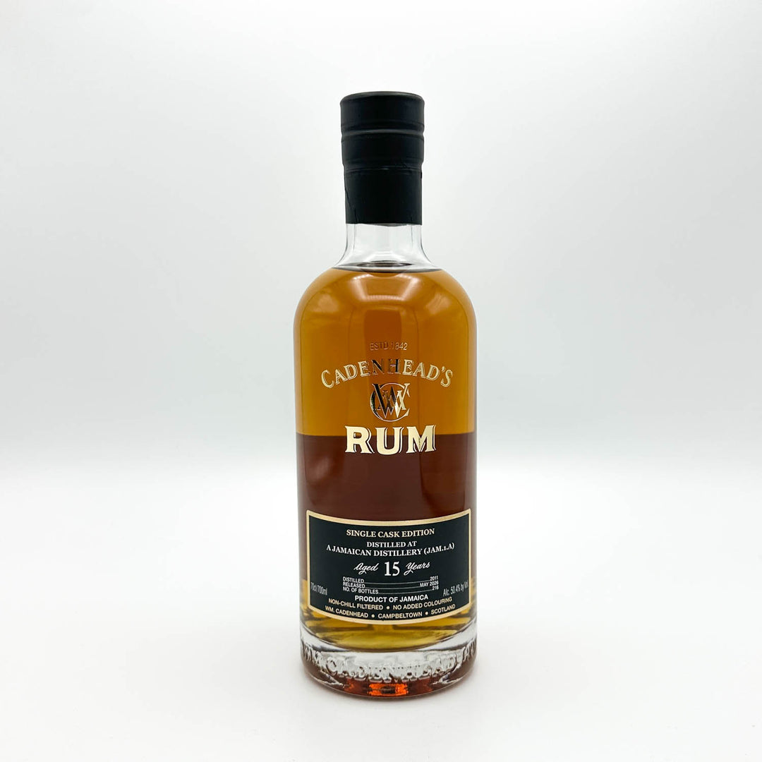 A bottle of Cadenhead's Rum Single Cask Edition, 15 Years Old, in a clear glass bottle with amber-brown liquid, a black cap, and a black and gold label, set against a plain light gray background.