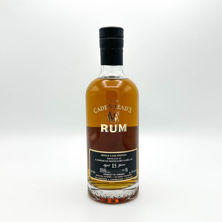 A bottle of Cadenhead's Rum Single Cask Edition, 15 Years Old, in a clear glass bottle with amber-brown liquid, a black cap, and a black and gold label, set against a plain light gray background.