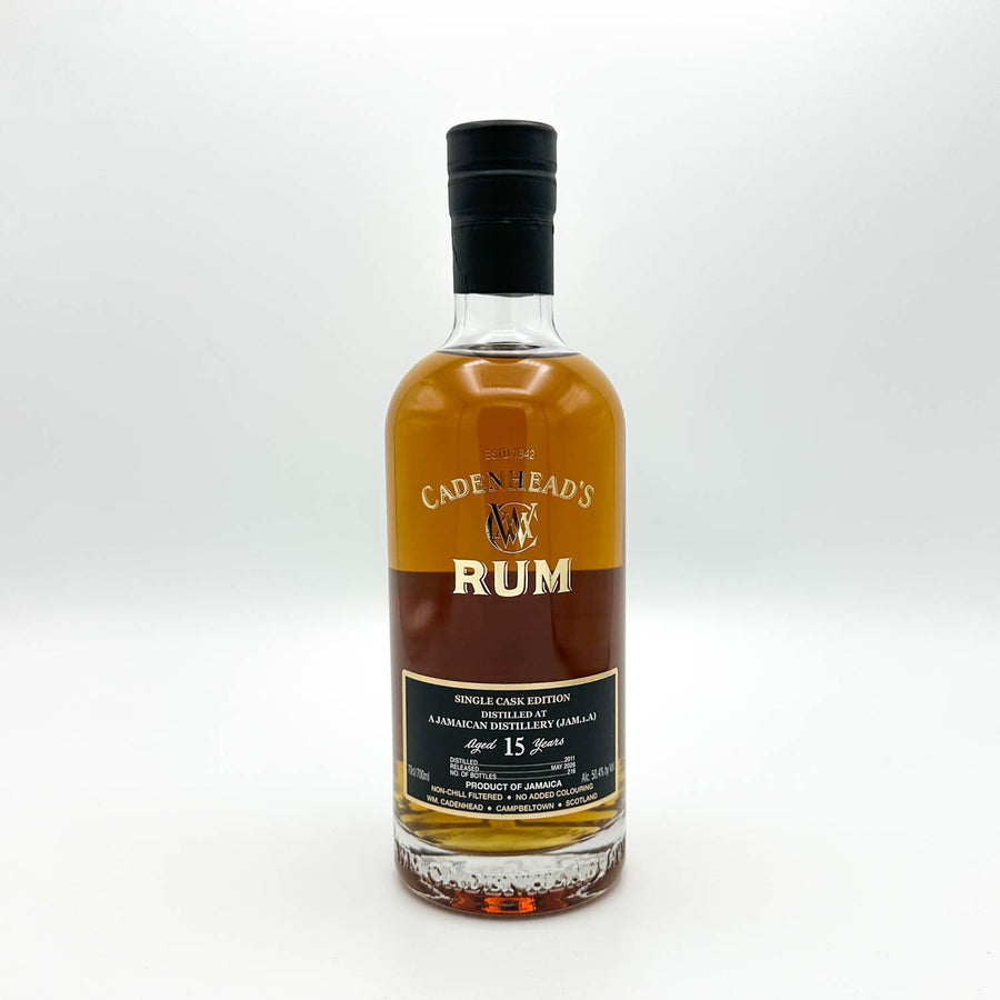 A bottle of Cadenhead's Rum Single Cask Edition, 15 Years Old, in a clear glass bottle with amber-brown liquid, a black cap, and a black and gold label, set against a plain light gray background.