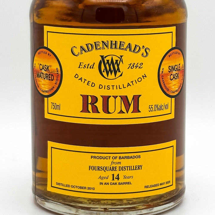 Bottle of Cadenhead's Rum with a yellow label on a white background