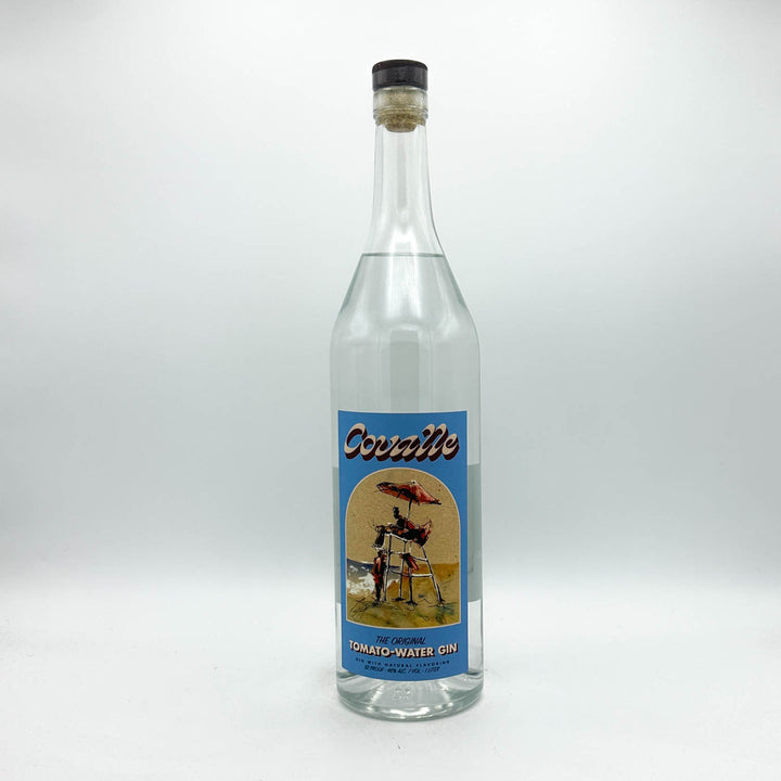 A clear glass bottle of CovalleTomato-Water Gin with a vintage-style blue label, photographed against a neutral light gray background.