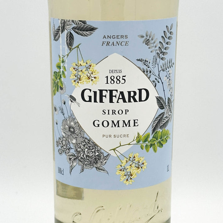 Giffard Sirop Gomme bottle with decorative label featuring floral designs on a light blue background.
