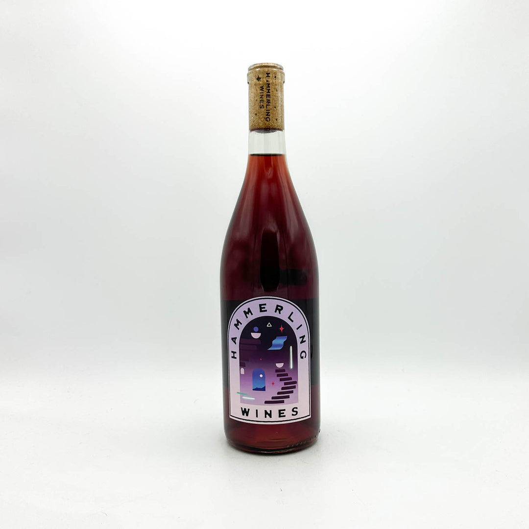 A bottle of Hammerling Wines red wine with a dark red liquid, a cork stopper, and a white label with a purple and blue illustration, set against a plain white background.