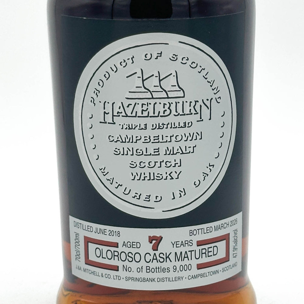 Close-up of a dark bottle label for Hazelbirk Single Malt Scotch Whisky, showing the circular white product label and the lower white maturity label with text including 'Aged 7 Years' and 'Oloroso Cask Matured'.