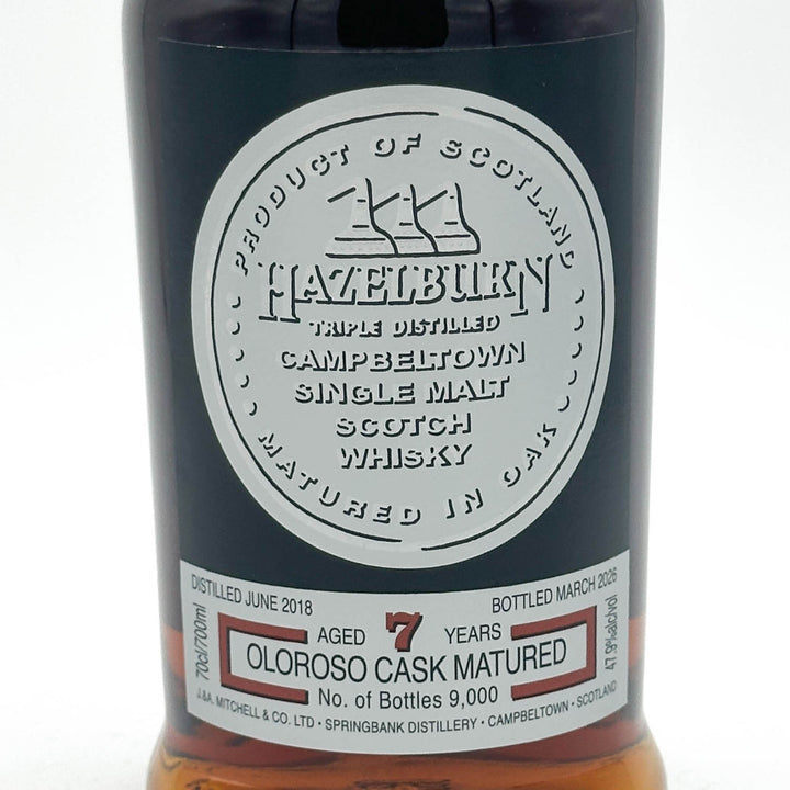 Close-up of a dark bottle label for Hazelbirk Single Malt Scotch Whisky, showing the circular white product label and the lower white maturity label with text including 'Aged 7 Years' and 'Oloroso Cask Matured'.