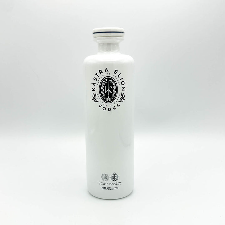 A tall, white glass bottle of Kástra Elion Vodka with a black printed logo on the front, set against a seamless light gray studio background.