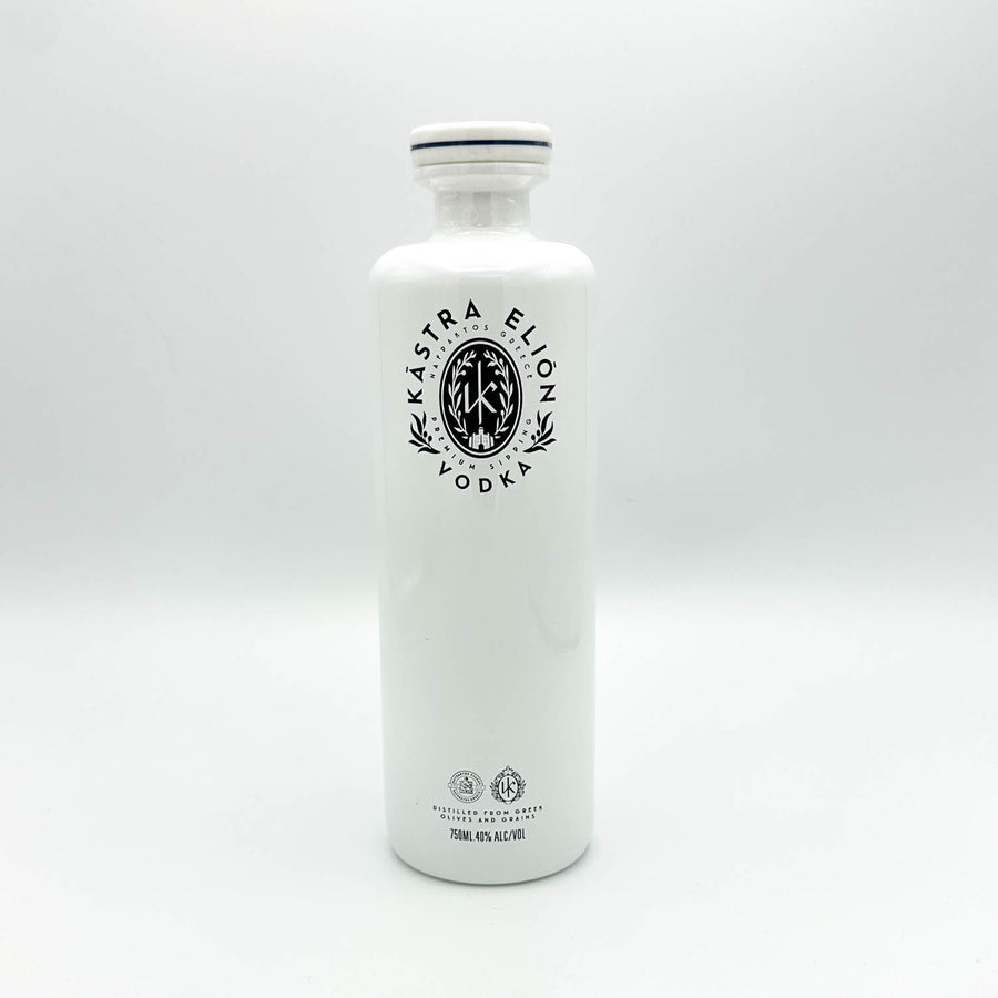 A tall, white glass bottle of Kástra Elion Vodka with a black printed logo on the front, set against a seamless light gray studio background.
