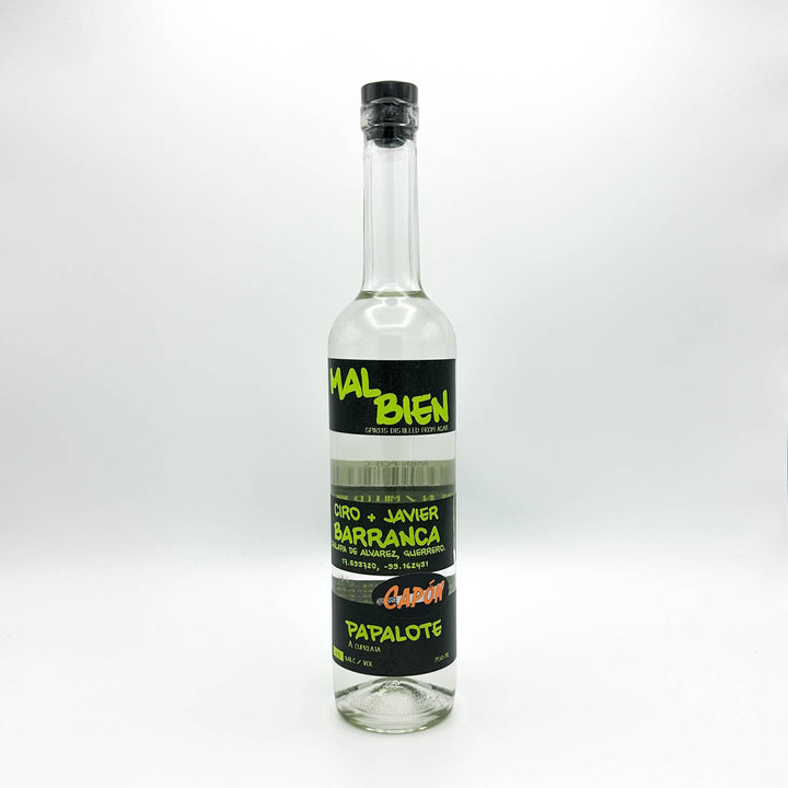 A clear bottle of Mal Bien Ciro + Javier Barranca Capón Papalote spirit distilled from agave, featuring black labels with bright green and orange text.