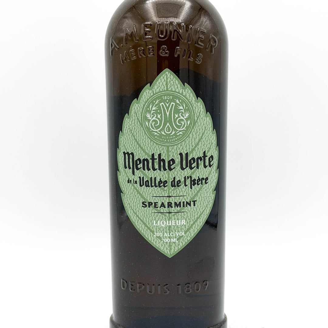 Bottle of Menthe Verte liqueur with a green label on a white background