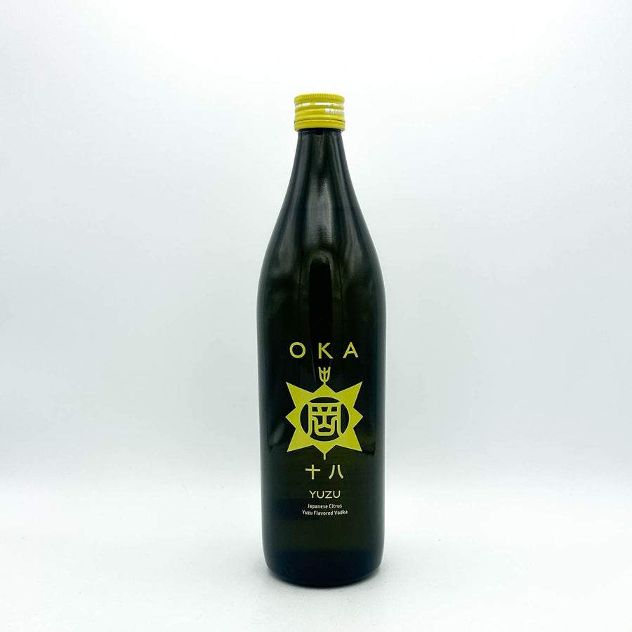 Black bottle of Oka Yuzu on a white background