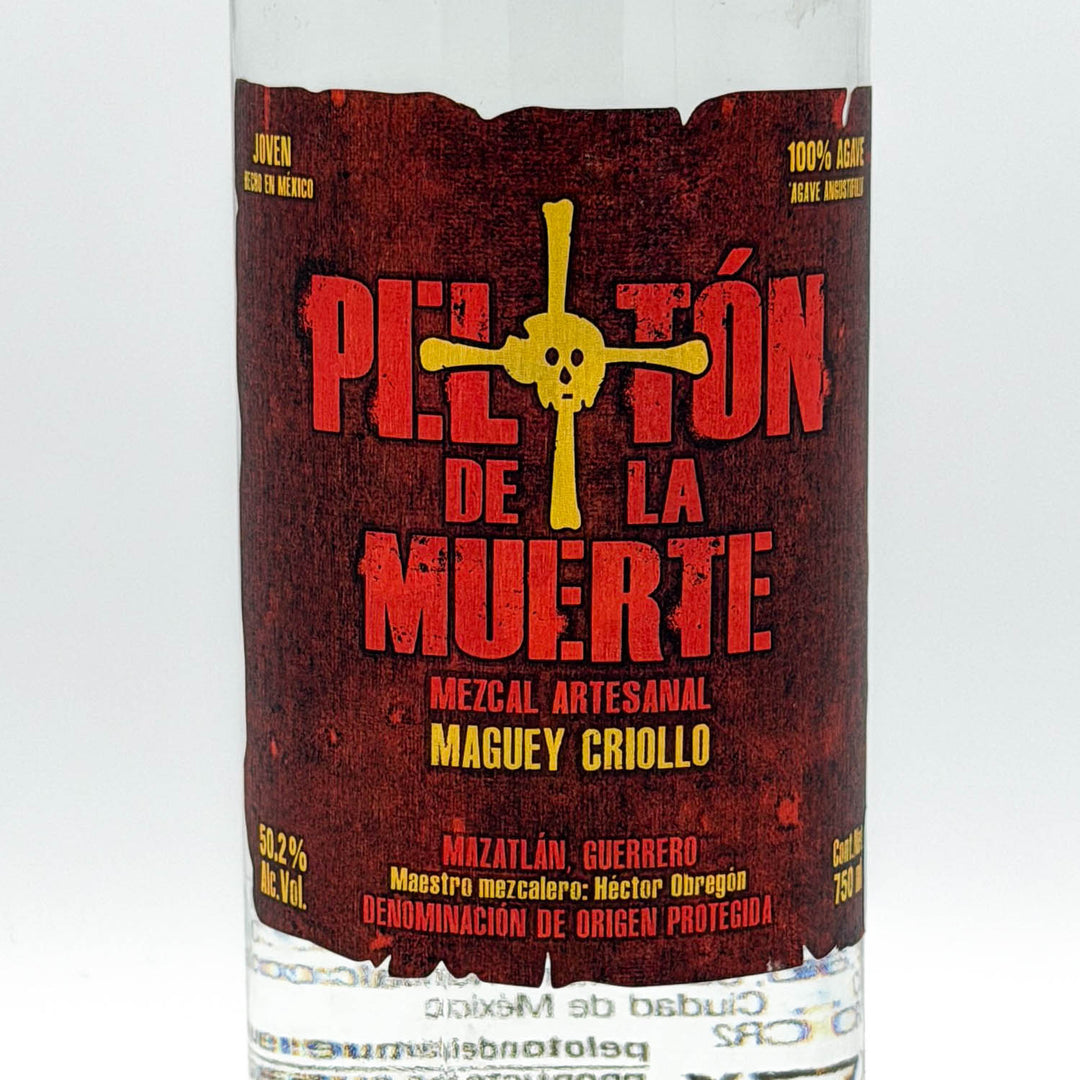 Bottle of 'Peloton de la Muerte' Mezcal with a red and yellow label on a white background