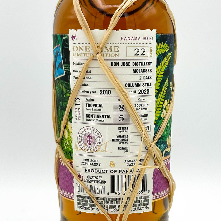 Bottle of Don Jose Distillery Panama 2010 rum with decorative string on a white background