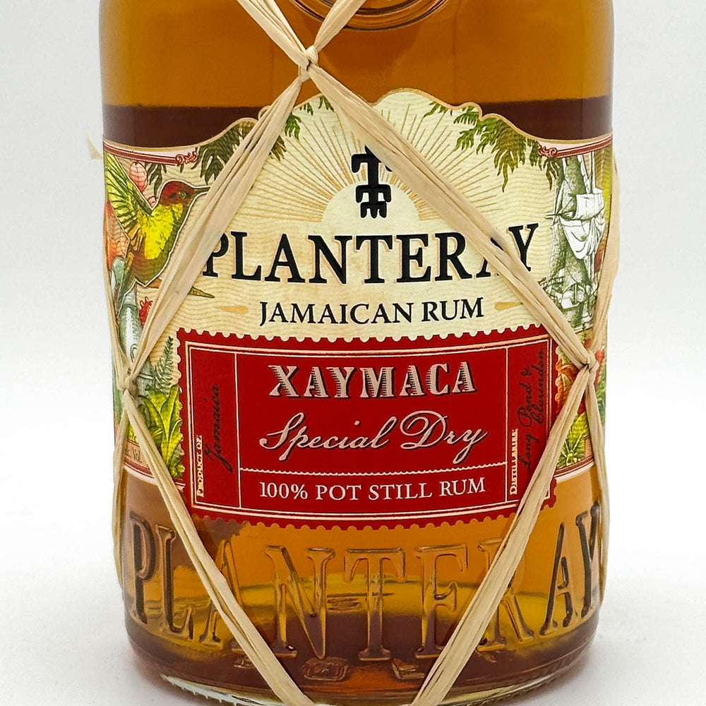 Bottle of Planters Y Cayama Jamaican Rum with decorative string on a white background