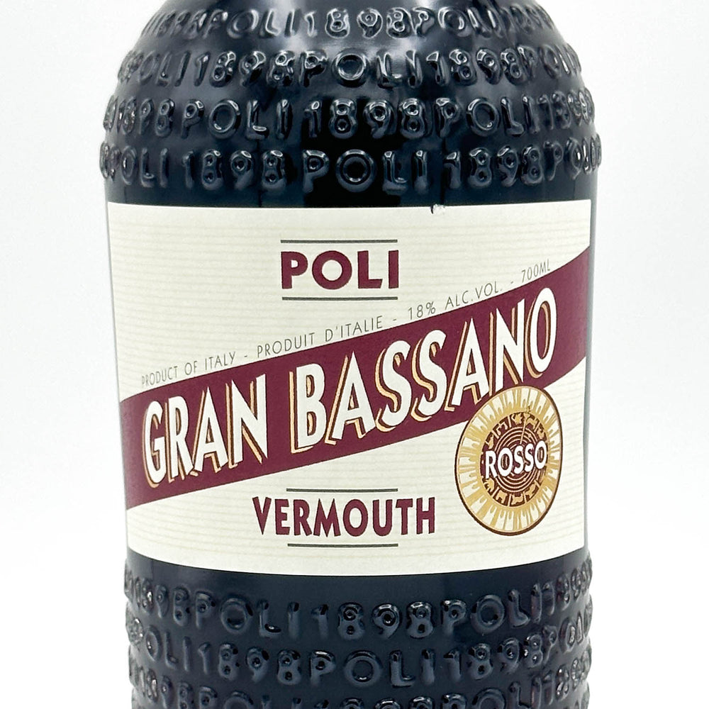 A close-up of a Poli Gran Bassano Vermouth Rosso bottle, showing the embossed brand name on the dark glass and the cream-colored label with burgundy and gold details.