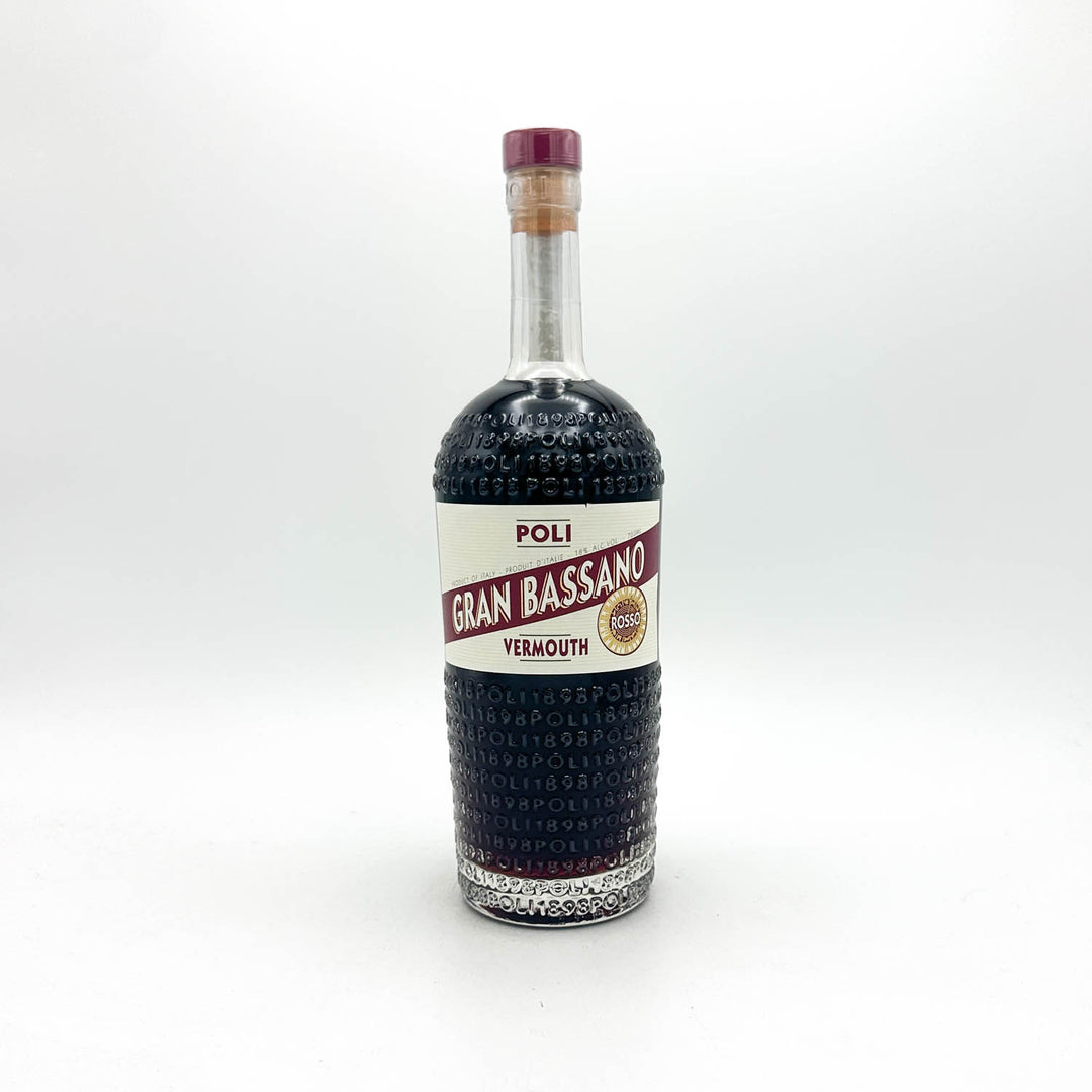A bottle of Poli Gran Bassano Vermouth non-alcoholic, featuring a textured dark glass body, a white and red label, and a purple cork stopper, set against a plain white background.