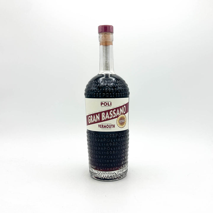 A bottle of Poli Gran Bassano Vermouth non-alcoholic, featuring a textured dark glass body, a white and red label, and a purple cork stopper, set against a plain white background.