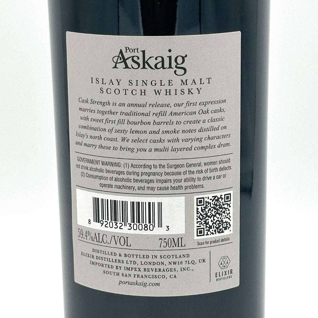 Close-up of the back label of a Port Askaig Islay Single Malt Scotch Whisky bottle, showing product details, barcode, QR code, and distiller information on a dark bottle background.