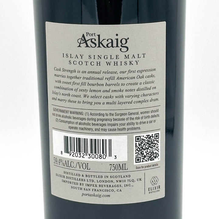 Close-up of the back label of a Port Askaig Islay Single Malt Scotch Whisky bottle, showing product details, barcode, QR code, and distiller information on a dark bottle background.