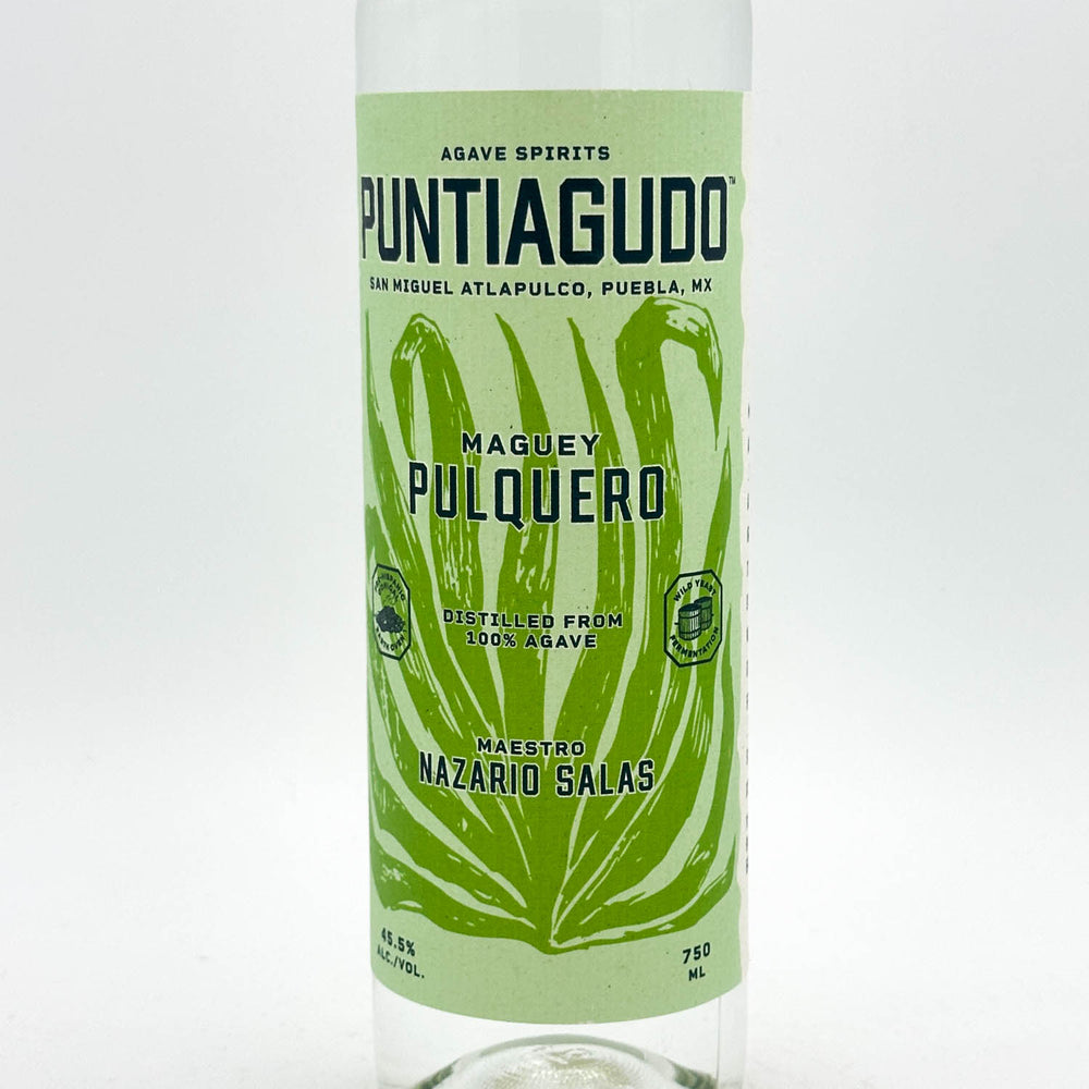 A clear glass bottle of Puntiguudo Maguey Pulquero agave spirits with a light green label featuring a dark green agave leaf design and black text.
