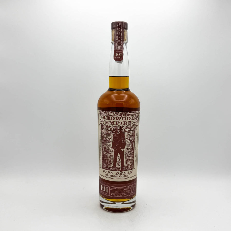 A bottle of 101 Redwood Empire Pipe Dream single malt whisky, featuring a brown and beige label with an illustration of a pipe player, set against a plain light gray background.