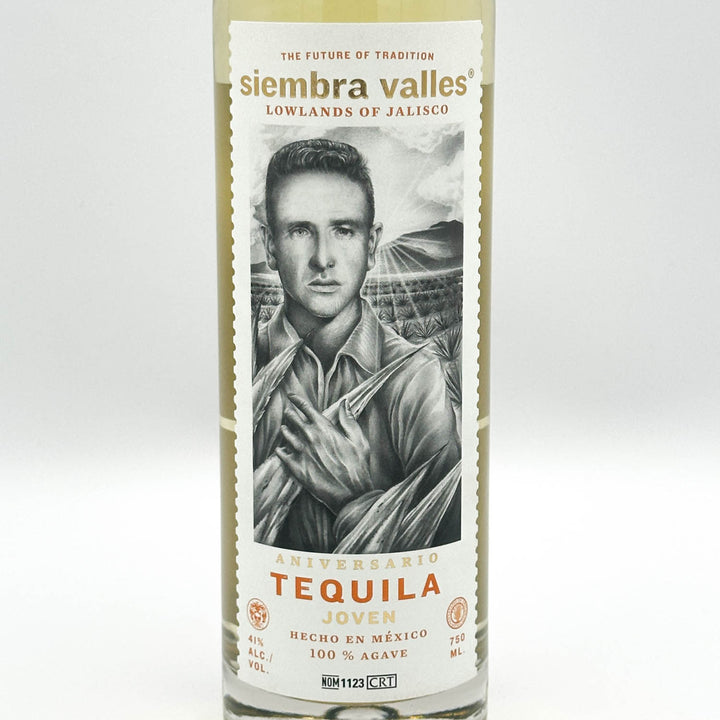 A bottle of Sierra Valles Tequila Joven on a light gray background. The label features a black and white portrait of a man, with gold and orange text reading 'siembra valles' and 'TEQUILA JOVEN'.