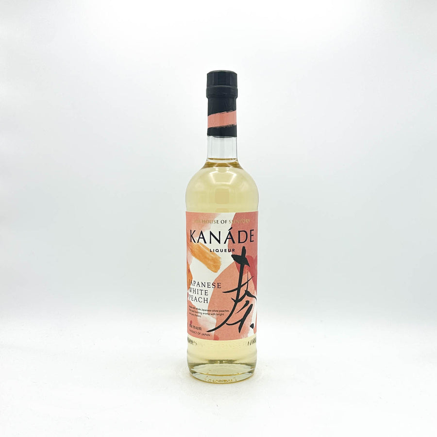 A bottle of Kanade Japanese White Peach syrup, featuring a clear glass bottle filled with pale yellow liquid, a pink and orange label with black calligraphy, and a black cap, set against a plain white background.