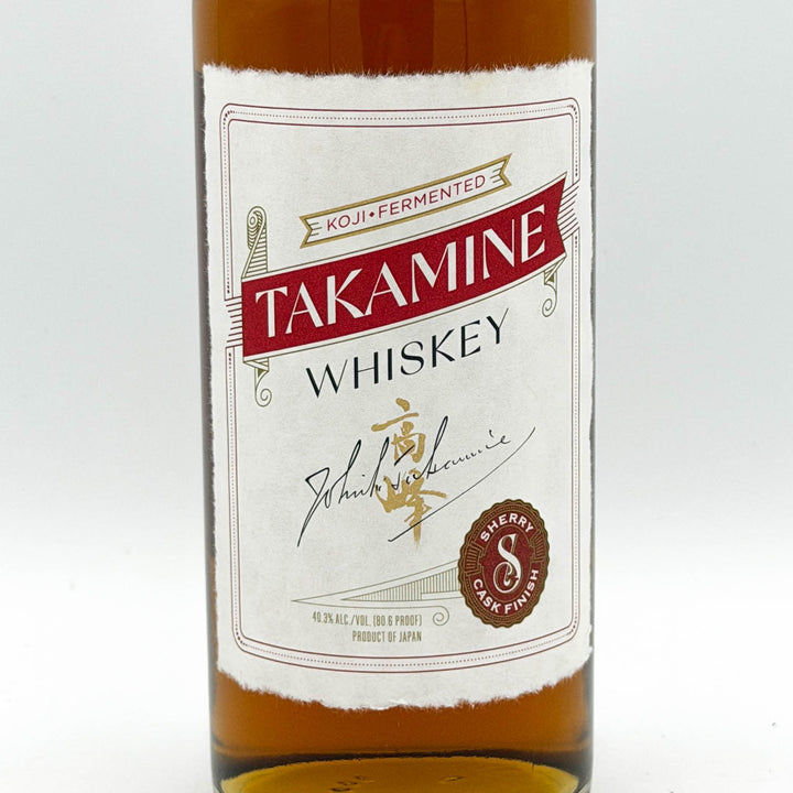 Bottle of Takamine Whiskey with a white label on a white background