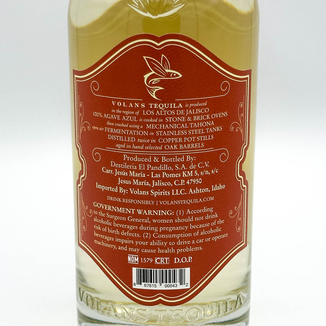 A bottle of Volans Tequila tequila with a large red and gold label showing detailed product information, photographed against a clean white background.