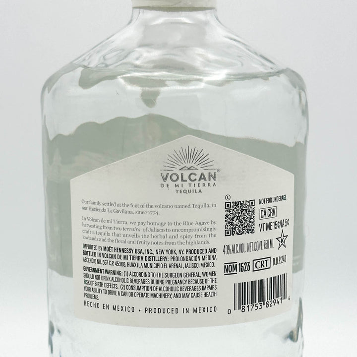 Clear Volcan de Mi Tierra Tequila bottle with label on a white background