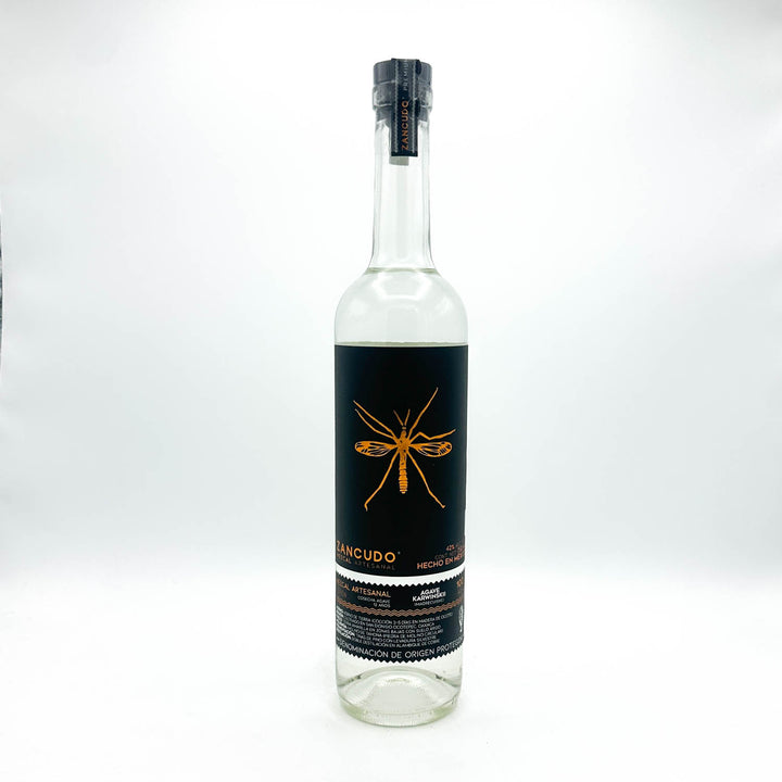 Clear bottle with black label featuring a gold insect design on a white background